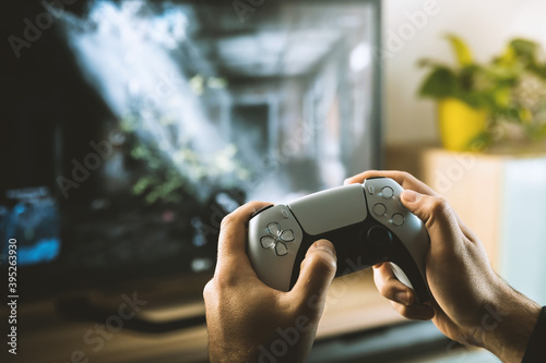 Close up of guy hands playing the video game at home. Modern gamepad.
