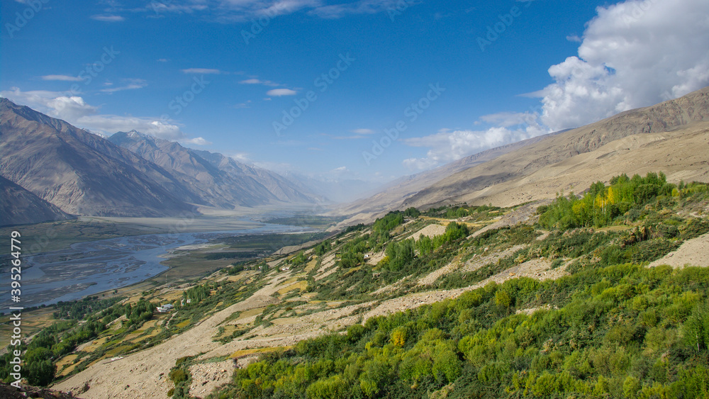 Panoramic view on Panj river valley in Wakhan Corridor and Hindu Kush mountain range in Afghanistan near Yamchun, Gorno-Badakshan, Tajikistan Pamir