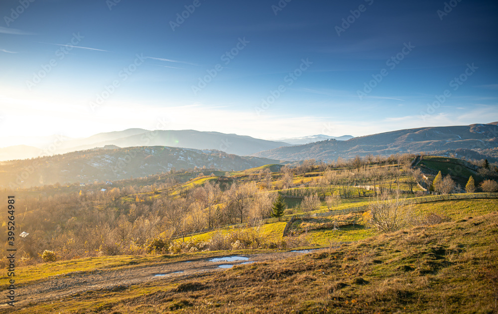Sunset over the forests and villages from Doftana Valley in Romania at the bottom of Baiului Mountains in autumn landscape after a freezing day Sunset over the forests and villages from Doftana Valley in Romania at the bottom of Baiului Mountains in autumn landscape after a freezing day