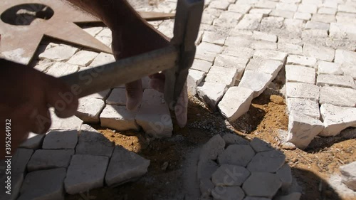 paver working on traditional portuguese cobblestone pavement 4k photo