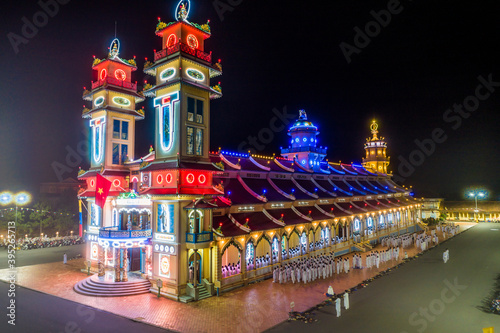 Aerial night view of meditating followers of the Cao Dai religion during Mid Autumn festival of Cao Dai people ( Caodaism) around temple in Tay Ninh city, Vietnam.