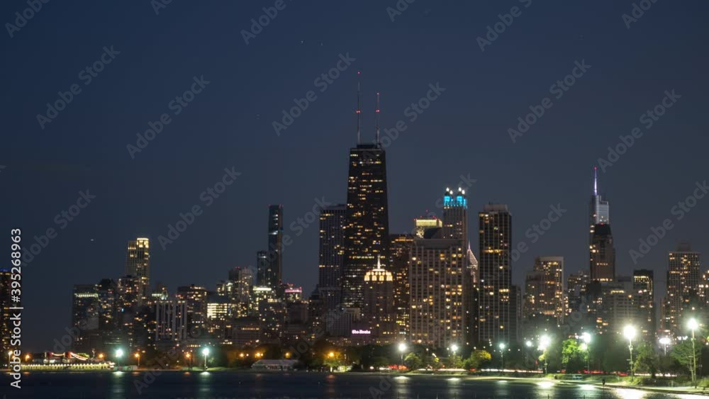 Day to night blue hour time lapse of downtown Chicago zooming out. Includes moving traffic with the Hancock Center, Drake Hotel, Willis Tower, and Lake Michigan.