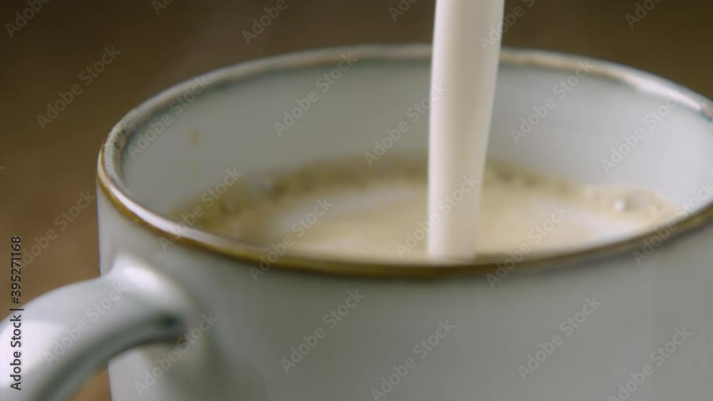 PAN RIGHT 60fps, frothy oat milk is poured into a cup to make a cappuccino PAN RIGHT 60fps, frothy oat milk is poured into a cup to make a cappuccino