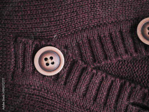 Macro snapshot of knitted texture. Warm sweater. Fashion and texture concept with button in the middle