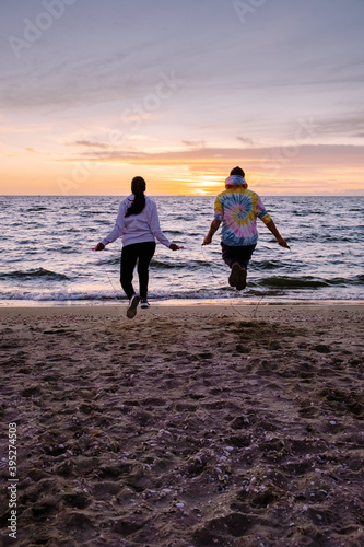 people with jumprope exersise on the beach, couple men and woman exersise together outsied on the beach in the Netherlands playing with sportwear photo