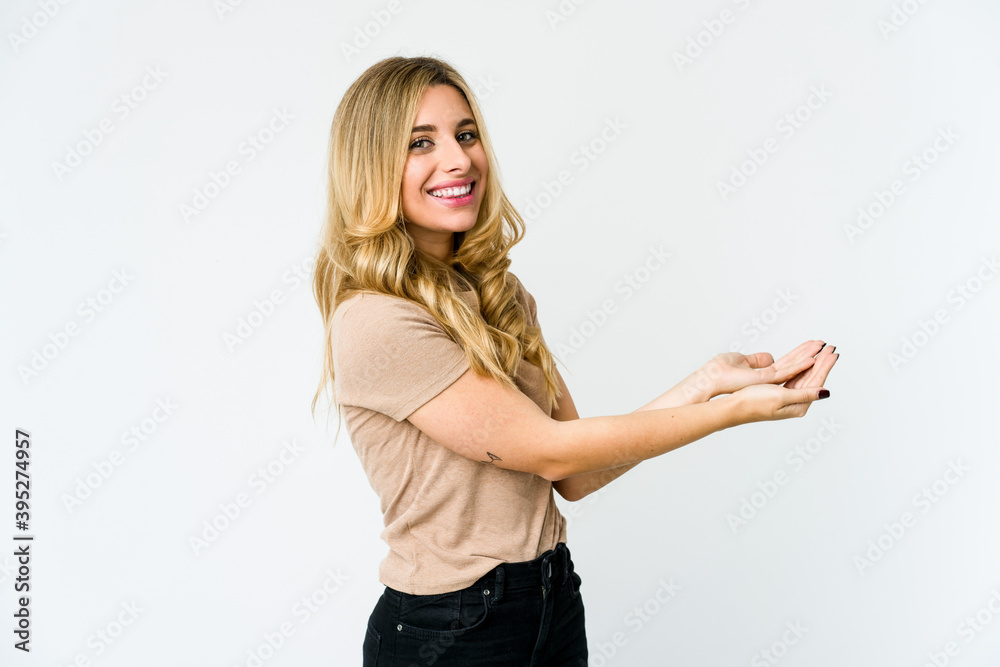 Young caucasian blonde woman holding a copy space on a palm.