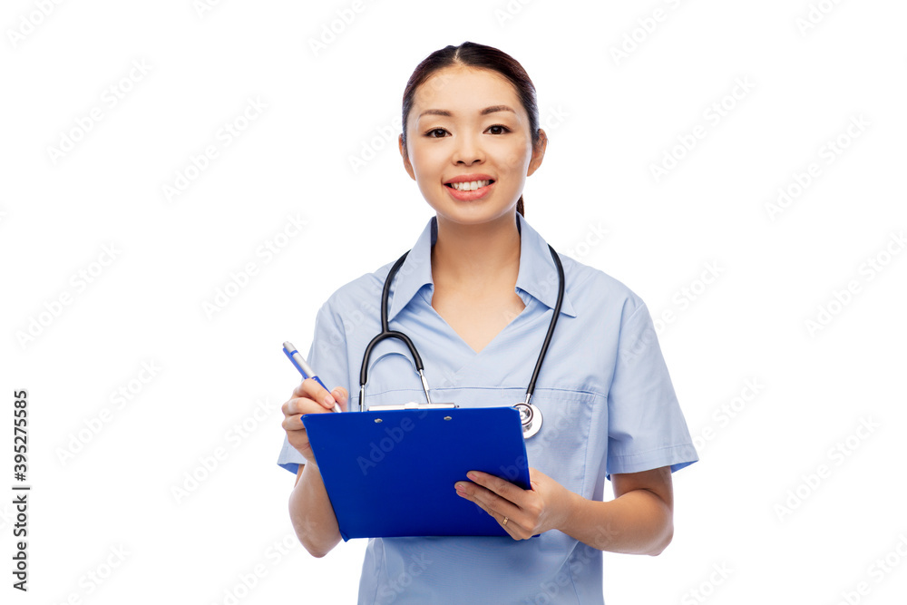 medicine, profession and healthcare concept - happy smiling asian female doctor or nurse in blue uniform with clipboard and pen over white background medicine, profession and healthcare concept - happy smiling asian female doctor or nurse in blue uniform with clipboard and pen over white background