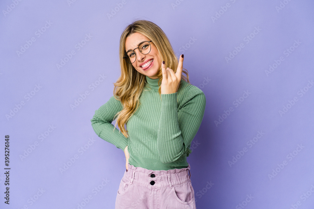 Young caucasian blonde woman showing rock gesture with fingers Young caucasian blonde woman showing rock gesture with fingers