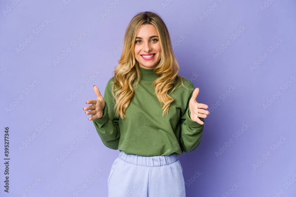 Young caucasian blonde woman holding something with both hands, product presentation. Young caucasian blonde woman holding something with both hands, product presentation.