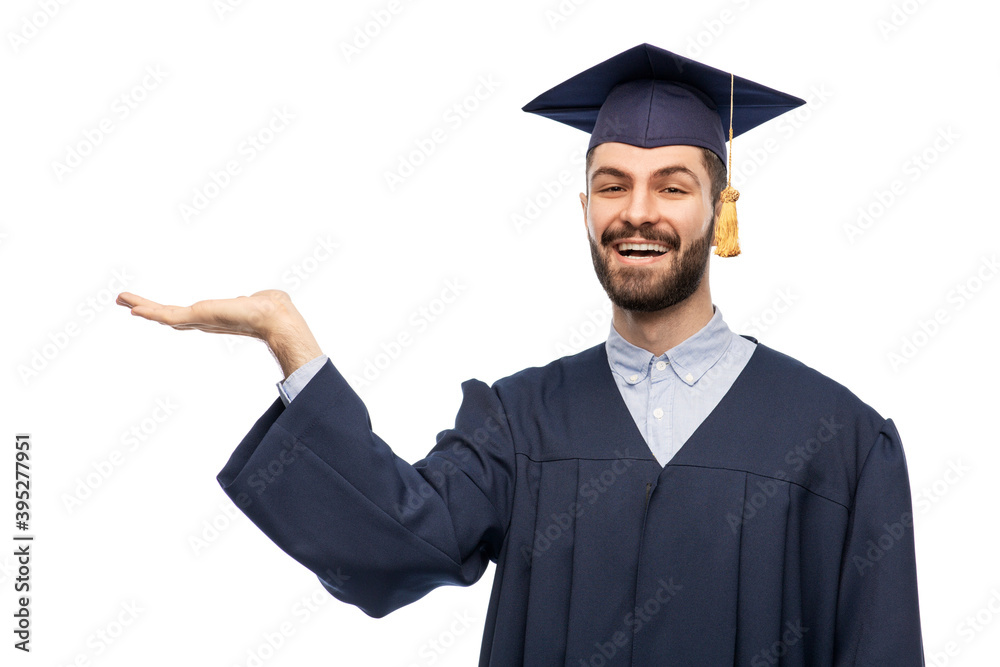 education, graduation and people concept - happy smiling male graduate student in mortar board and bachelor gown holding something imaginary on his hand over white background education, graduation and people concept - happy smiling male graduate student in mortar board and bachelor gown holding something imaginary on his hand over white background