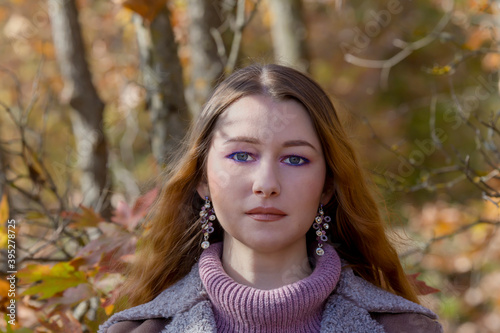 Young beautiful woman on the background of the autumn forest