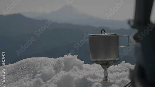 a man boiling water in a winter mountain photo