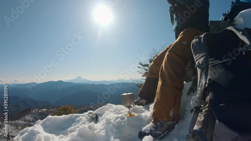 a man boiling water in a winter mountain photo