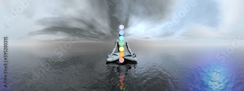 Man meditating and chakra colors in a panoramic landscape with water - 3D render