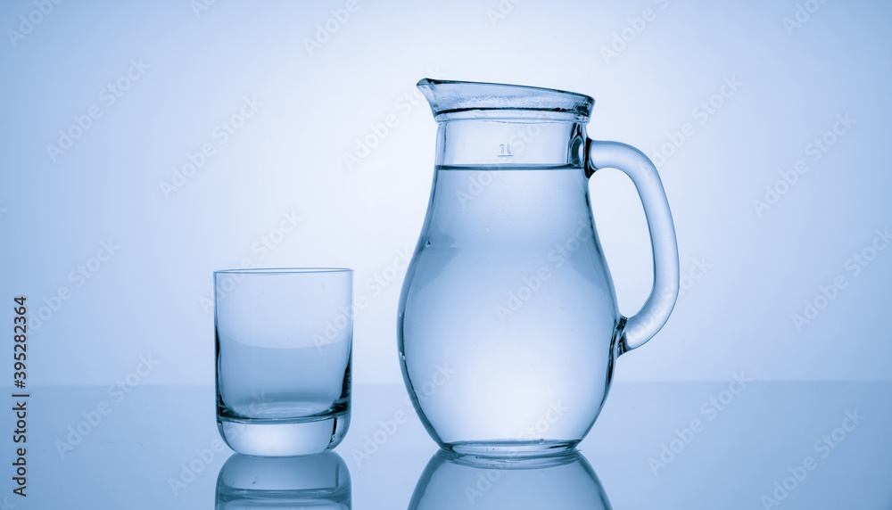 Pitcher with drinking water and a glass with a drink, blue tone Pitcher with drinking water and a glass with a drink, blue tone