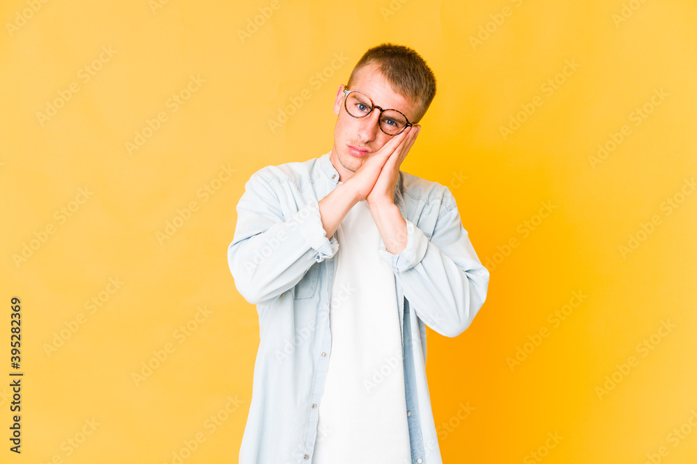 Young caucasian handsome man yawning showing a tired gesture covering mouth with hand. Young caucasian handsome man yawning showing a tired gesture covering mouth with hand.