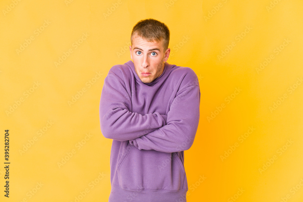 Young caucasian handsome man shrugs shoulders and open eyes confused. Young caucasian handsome man shrugs shoulders and open eyes confused.