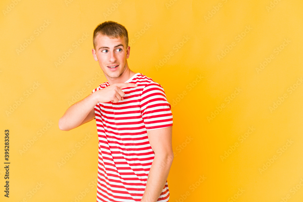 Young caucasian handsome man looks aside smiling, cheerful and pleasant. Young caucasian handsome man looks aside smiling, cheerful and pleasant.
