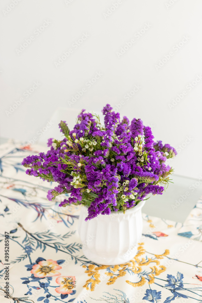 Cute flower arrangement with purple statice, decorating the dinner table Cute flower arrangement with purple statice, decorating the dinner table