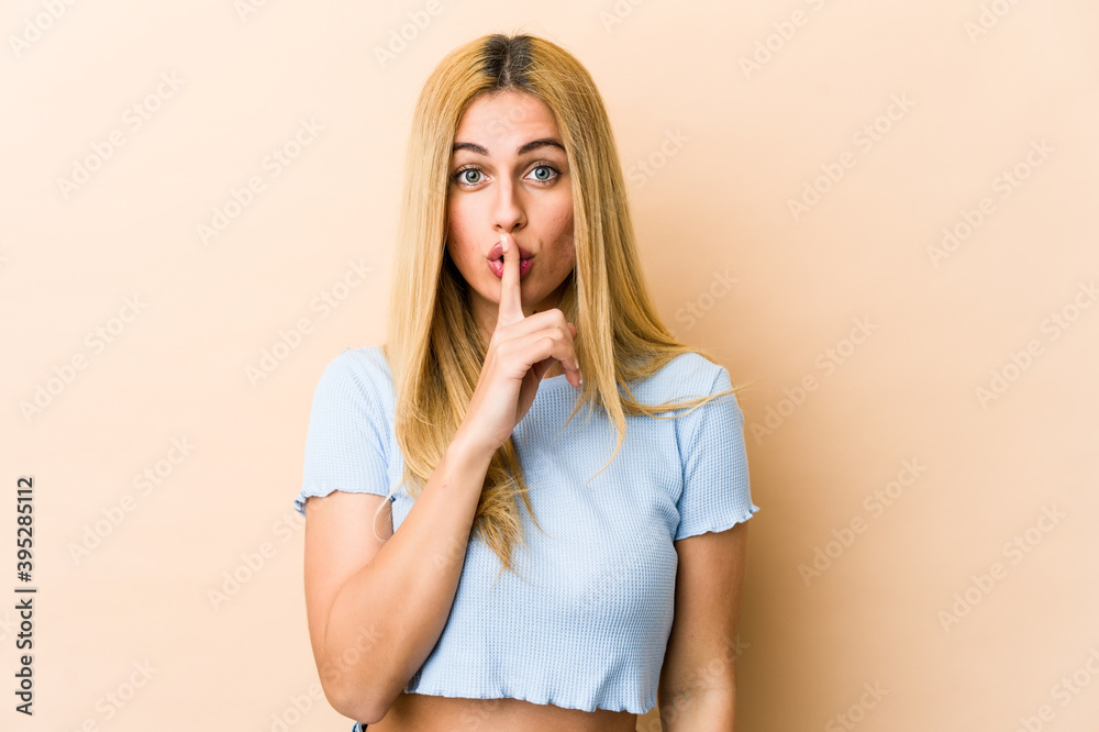 Young blonde caucasian woman keeping a secret or asking for silence. Young blonde caucasian woman keeping a secret or asking for silence.