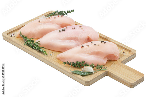 chicken fillet on a wooden cutting board with herbs and spices. white background isolate. space for text