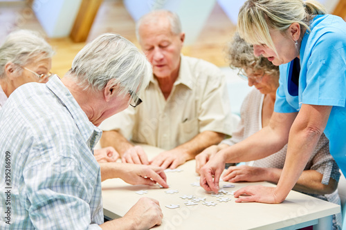 Gruppe Senioren mit Puzzle im Seniorenheim beim Spielen © Robert Kneschke