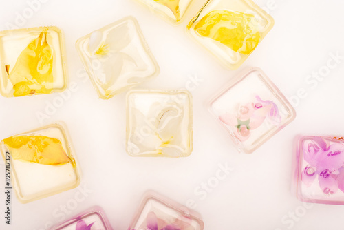top view of transparent fruit and vegetable ice cubes on white 