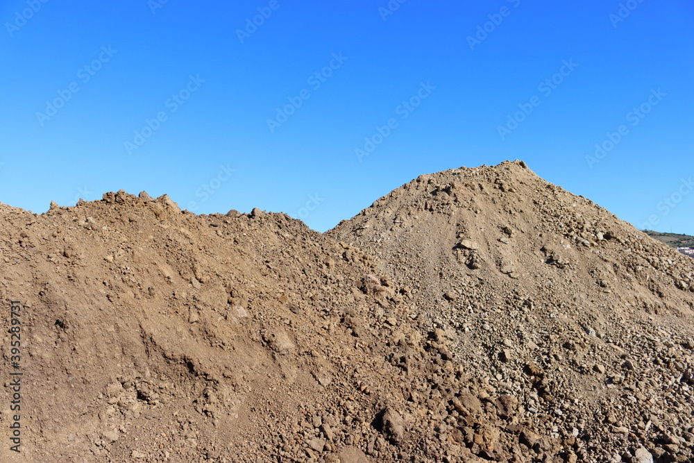 Close-up of a large pile of earth against the blue sky. Close-up of a large pile of earth against the blue sky.