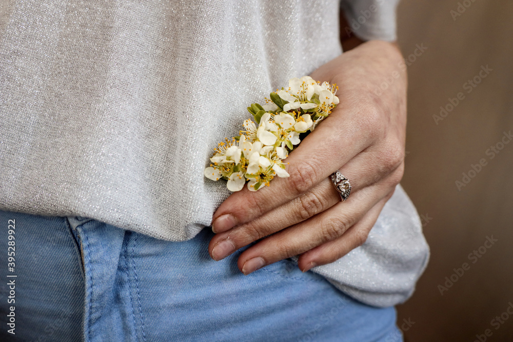Quarantine clothing. Flowering branch in the hand of a girl. Quarantine clothing. Flowering branch in the hand of a girl.
