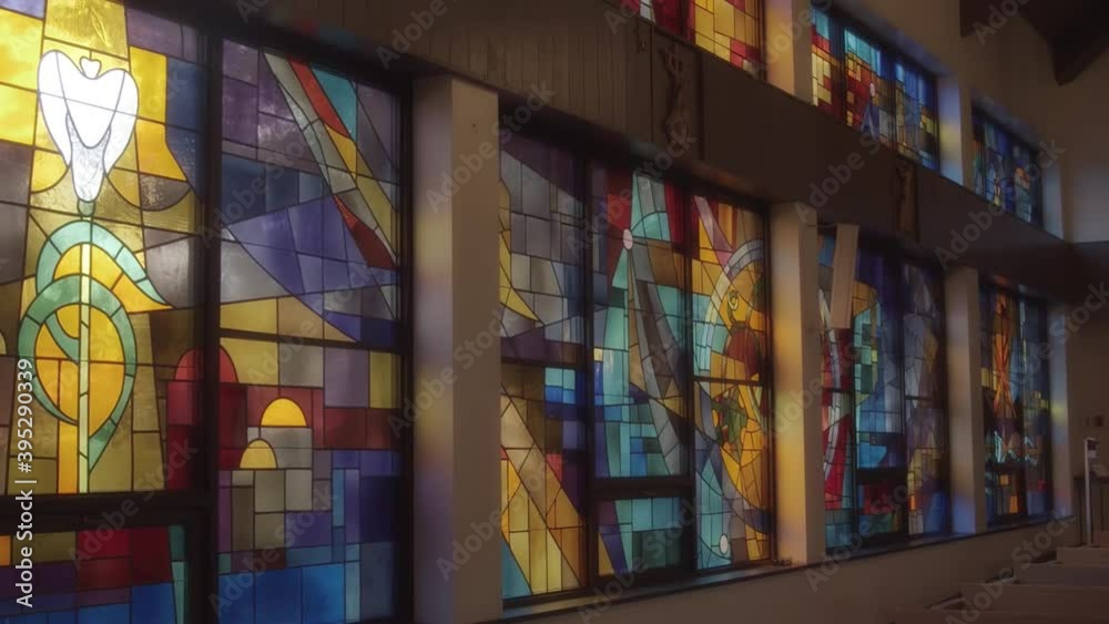A wall of beautiful stained glass in a catholic church A wall of beautiful stained glass in a catholic church