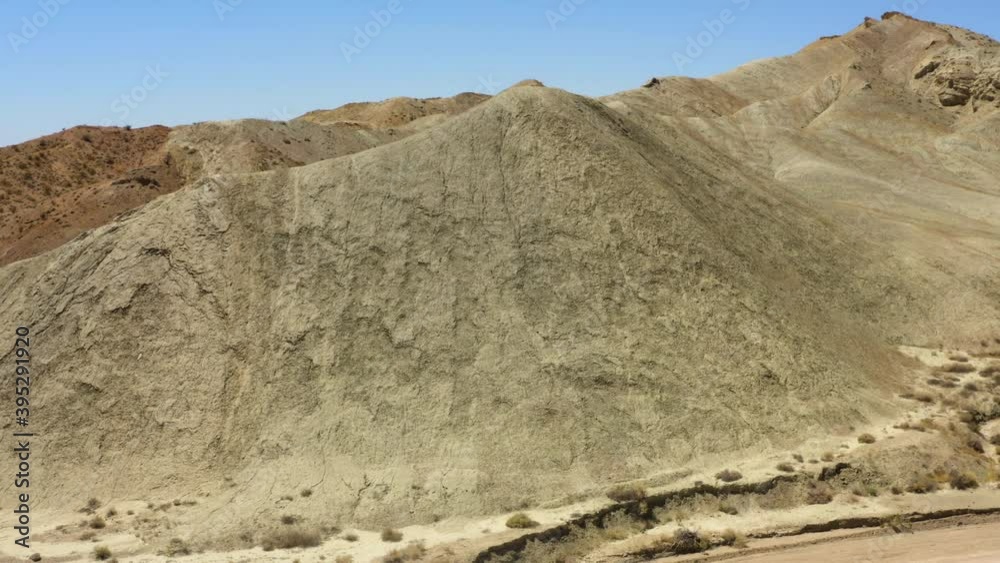 Rotating view around a section of dry sandy mountains in the Rainbow Basin part of the Mojave Desert; drone view. Rotating view around a section of dry sandy mountains in the Rainbow Basin part of the Mojave Desert; drone view.