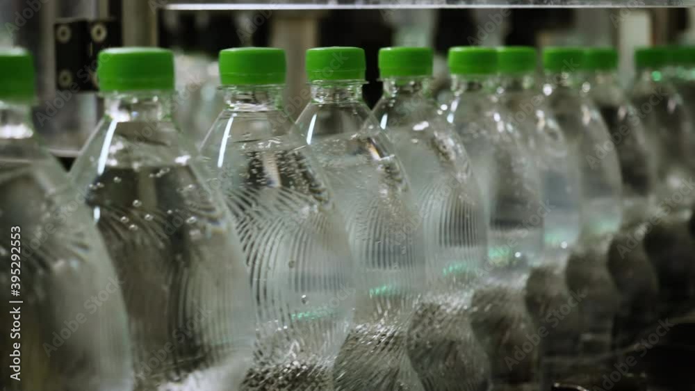 Close up of a transporter with filled bottles of fresh sparkling water in a filling factory Close up of a transporter with filled bottles of fresh sparkling water in a filling factory
