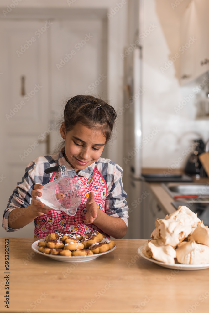 Little Girl Sprinkling Cookies With Powdered Sugar.