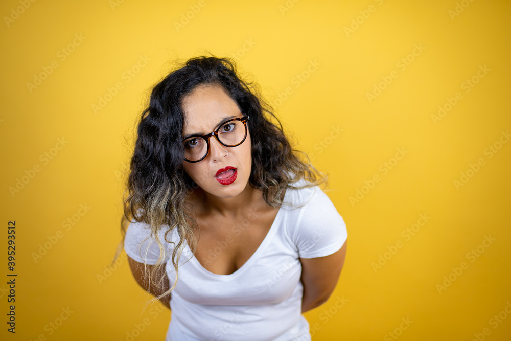 Young beautiful woman wearing casual white t-shirt over isolated yellow background afraid and shocked with surprise and amazed expression, fear and excited face.