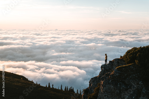Photos Hiker standing on cliff edge and looking at view on montain summit