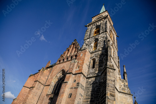 Medieval catholic church of Saint Jilji with gothic High clock tower in sunny autumn day, Nymburk, Central Bohemia, Czech Republic