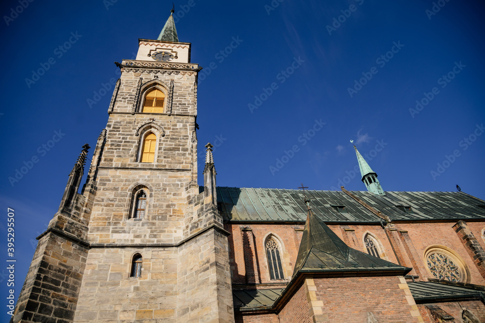 Medieval catholic church of Saint Jilji with gothic High clock tower in sunny autumn day, Nymburk, Central Bohemia, Czech Republic Medieval catholic church of Saint Jilji with gothic High clock tower in sunny autumn day, Nymburk, Central Bohemia, Czech Republic