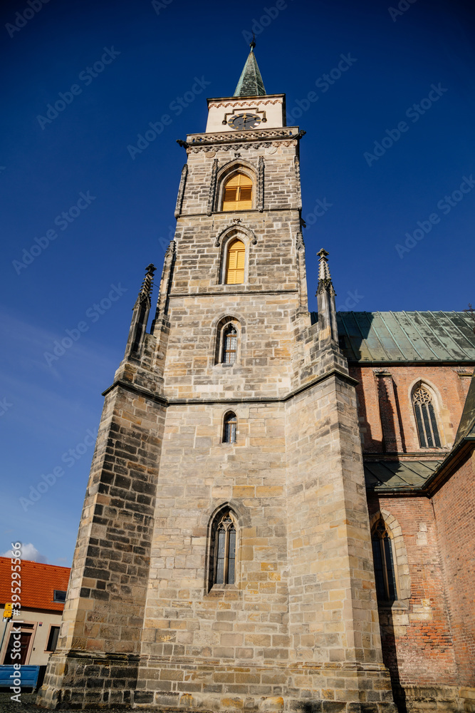 Medieval catholic church of Saint Jilji with gothic High clock tower in sunny autumn day, Nymburk, Central Bohemia, Czech Republic