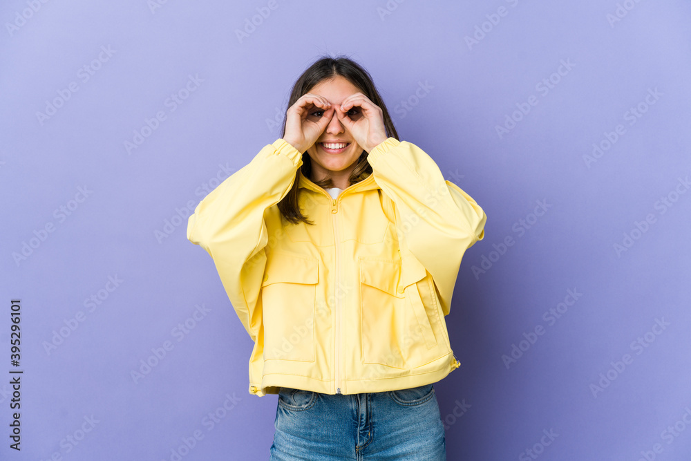 Young caucasian woman showing okay sign over eyes Young caucasian woman showing okay sign over eyes