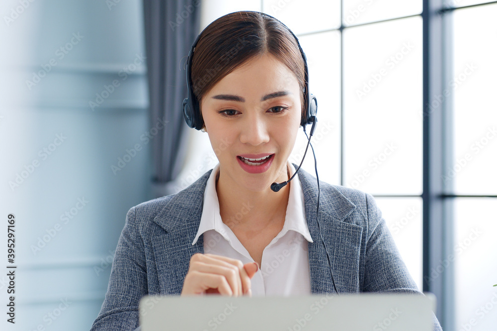 Young Asian businesswoman, call center, customer service with headset or headphone talking on video call conference or virtual meeting in office Young Asian businesswoman, call center, customer service with headset or headphone talking on video call conference or virtual meeting in office