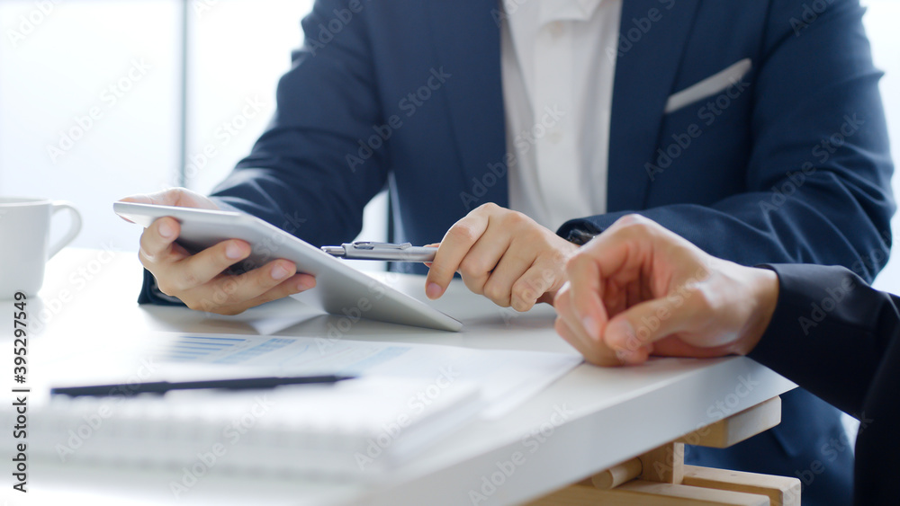Professional businessman in suit using tablet meeting about business finance, working in office Professional businessman in suit using tablet meeting about business finance, working in office