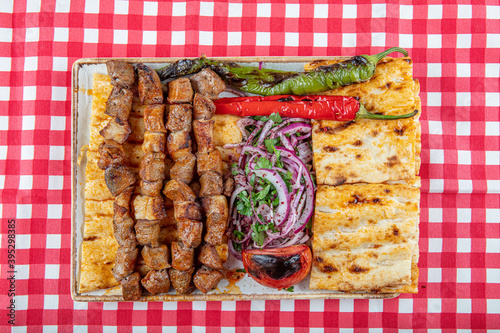 Turkish cuisine delicious ciger skewer. Liver skewer, Turkish Ciger Shish Kebab on small barbecue with tomatoes, delicious, natural, close-up looking. photo