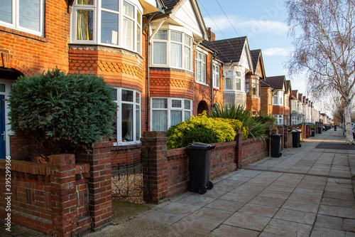 A typical row of English terraced houses with wheelie bins outside on the pavement