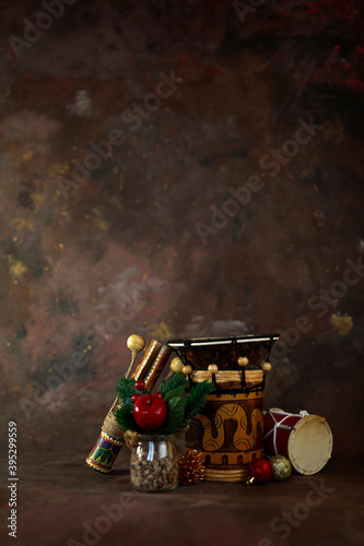 christmas and new year background for musician. musician percussion instruments set and christmas tree toys on dark background vertical orientation