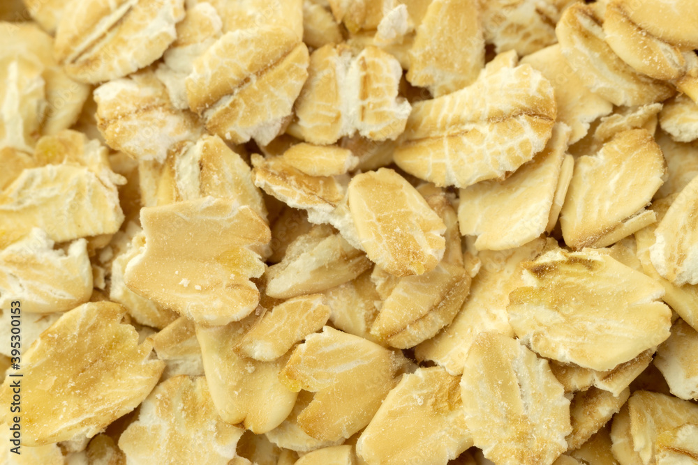 Raw oat flakes or oatmeal background texture macro close-up