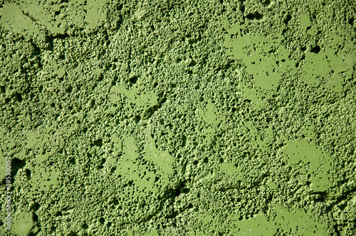 Green abstract wall texture of cement with contrasting shadows, background