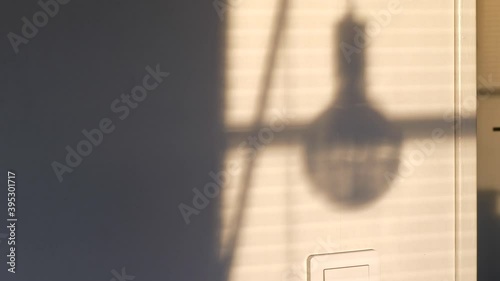 Time lapse of window sunshine and shadow of lamp moving on living room wall photo