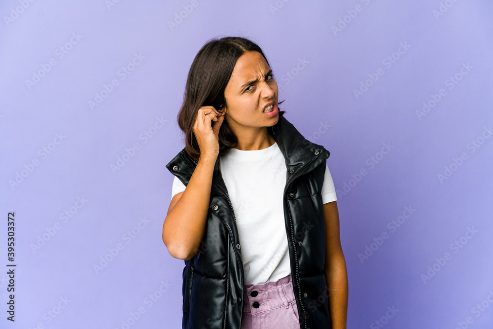 Young mixed race woman covering ears with fingers, stressed and desperate by a loudly ambient. Young mixed race woman covering ears with fingers, stressed and desperate by a loudly ambient.