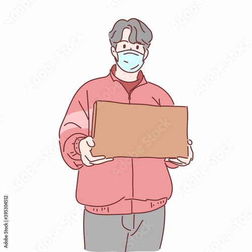Delivery man wearing medical mask holding box.
