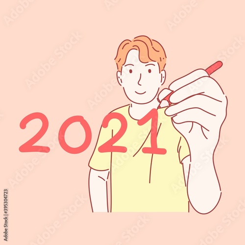 Man holding pen and writing 2021 in new year concept.
